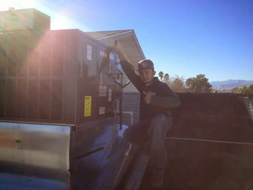 HVAC technician performing Heat Pump Repair on a rooftop unit in Chico